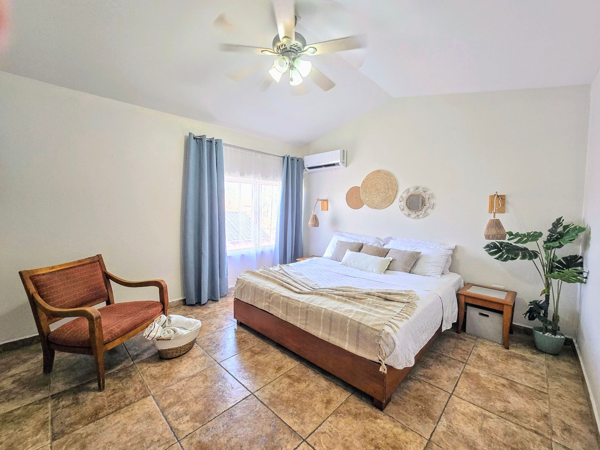 A bedroom with a large bed and a ceiling fan