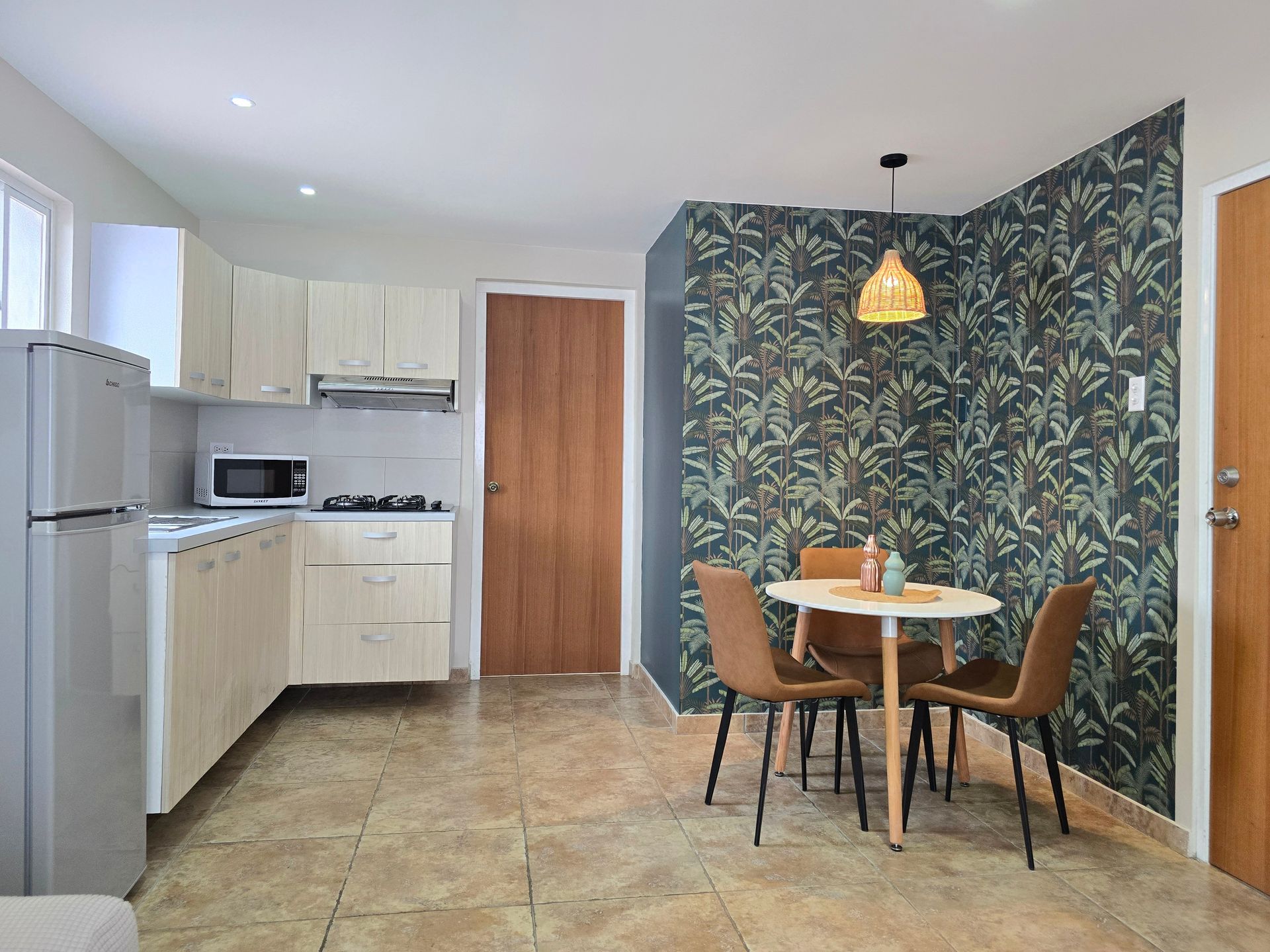 A kitchen with a sink , stove , microwave and refrigerator.