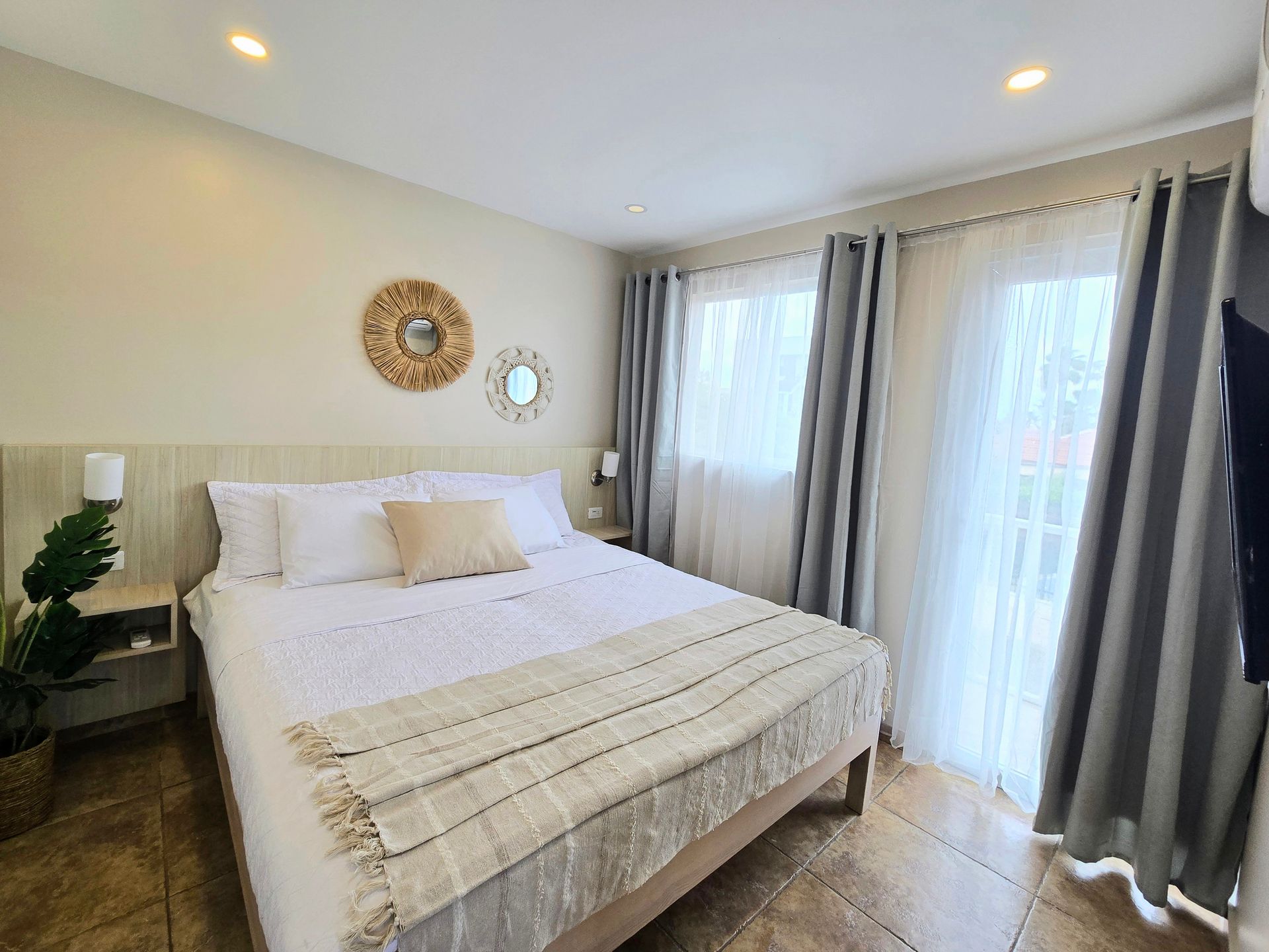 A bedroom with a large bed and a picture on the wall.