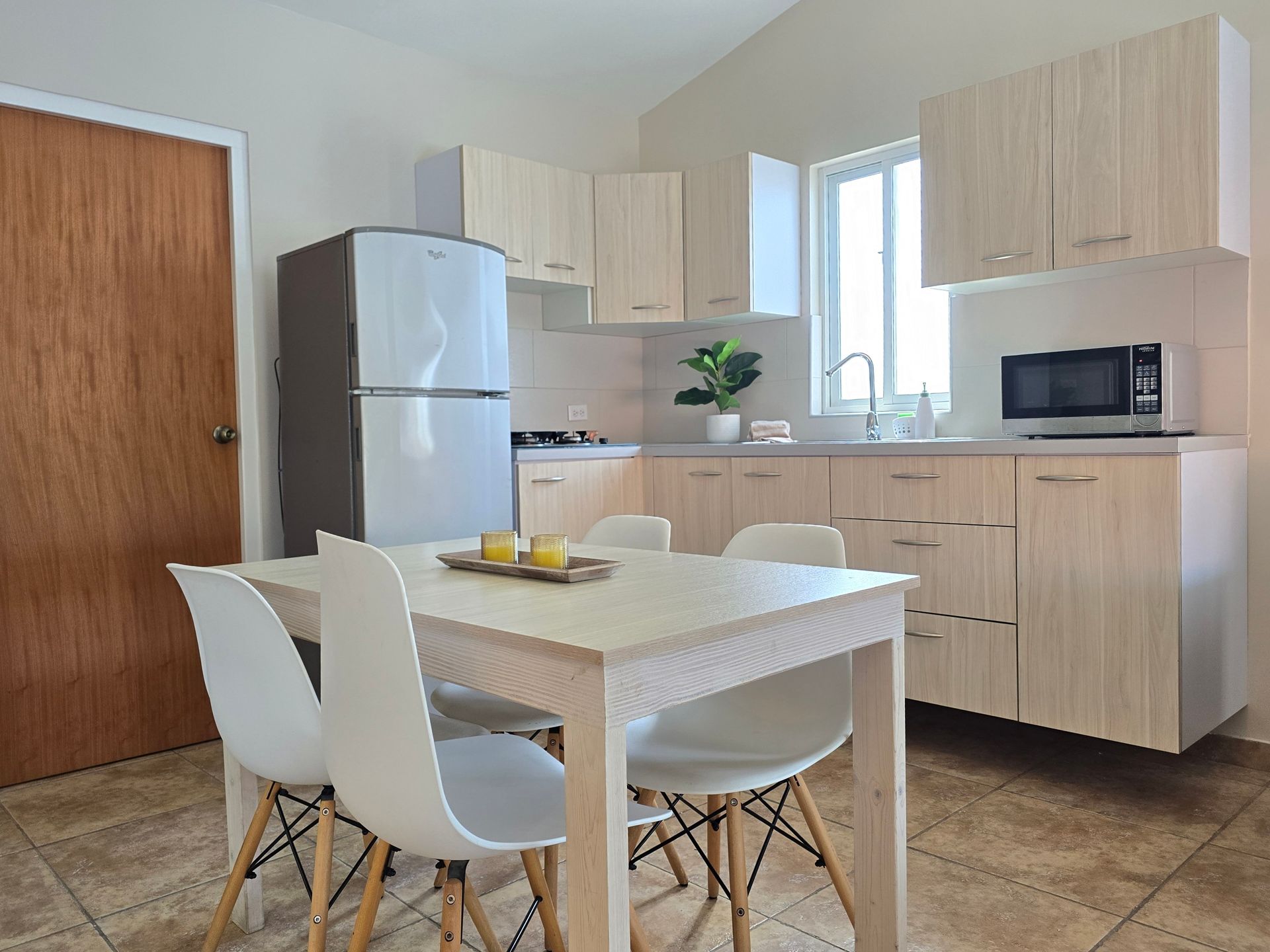 A living room with a table , chairs , and a television.
