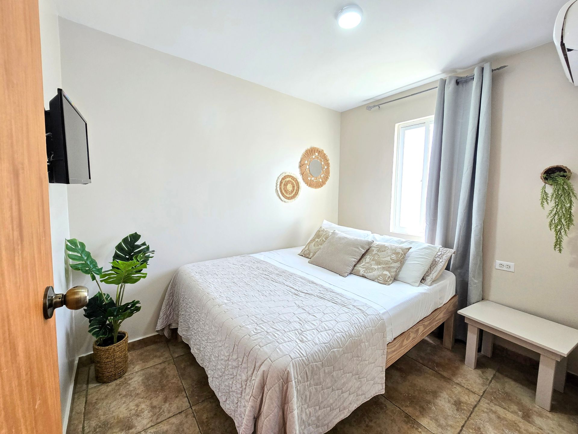 A bedroom with a bed , television and air conditioner.