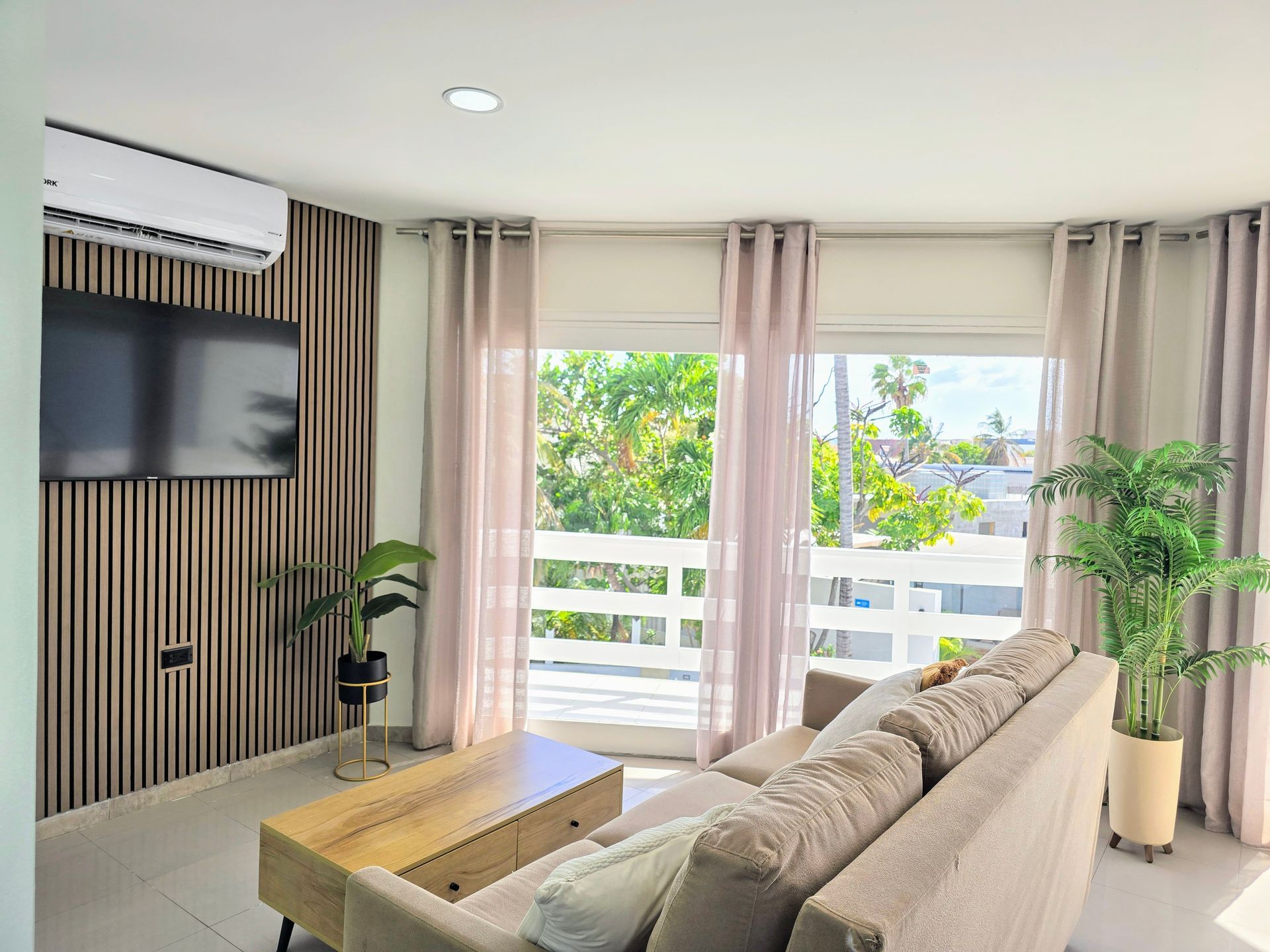 A living room with a couch , chair , table and television.