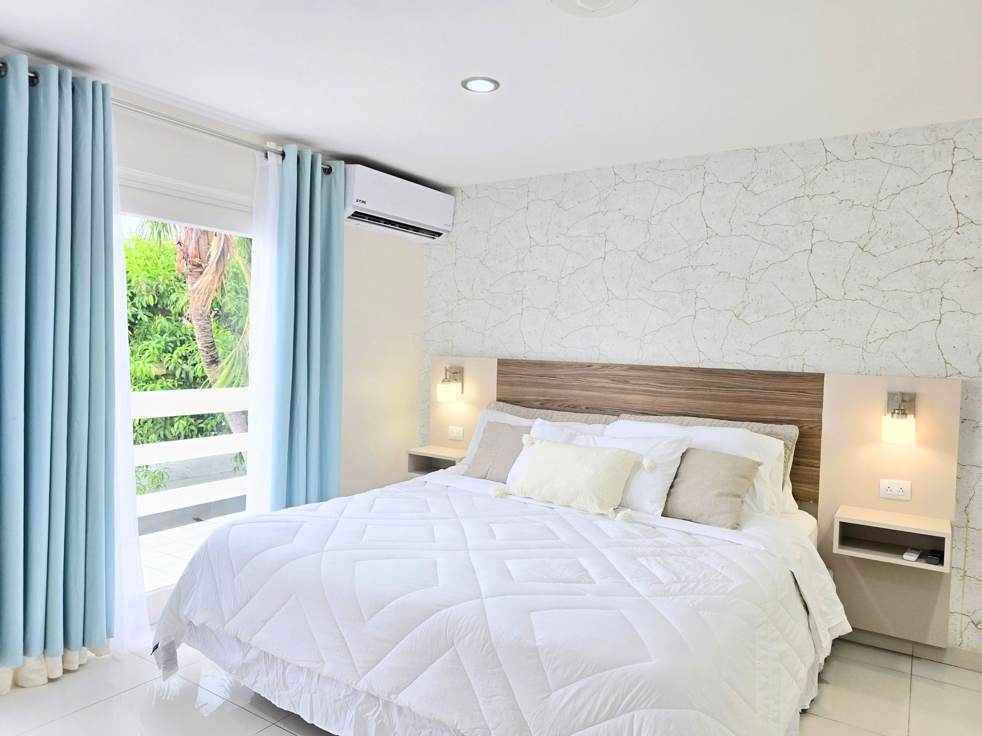 A bedroom with a king size bed and a blue couch.