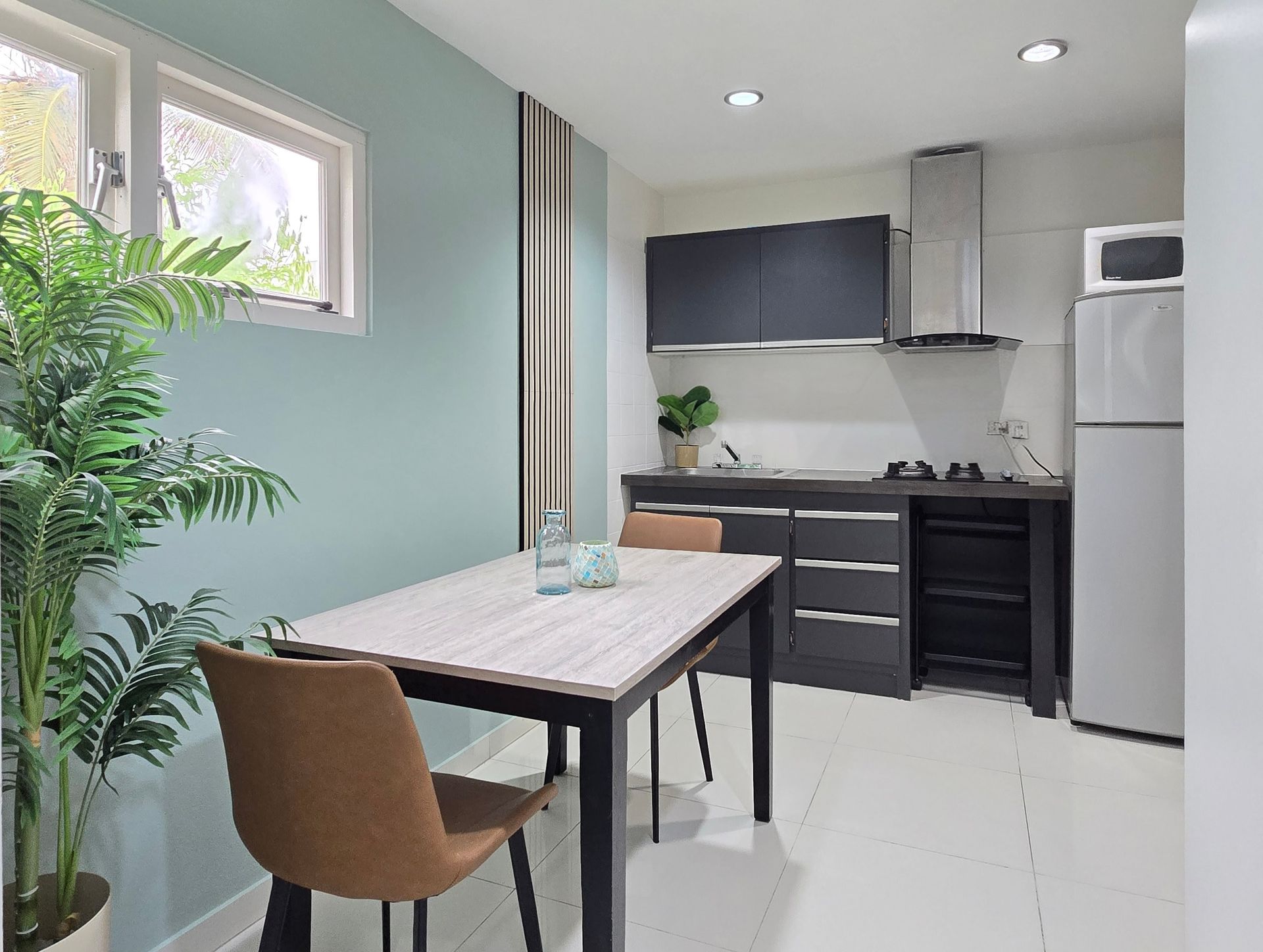 A kitchen with a table and chairs and a refrigerator