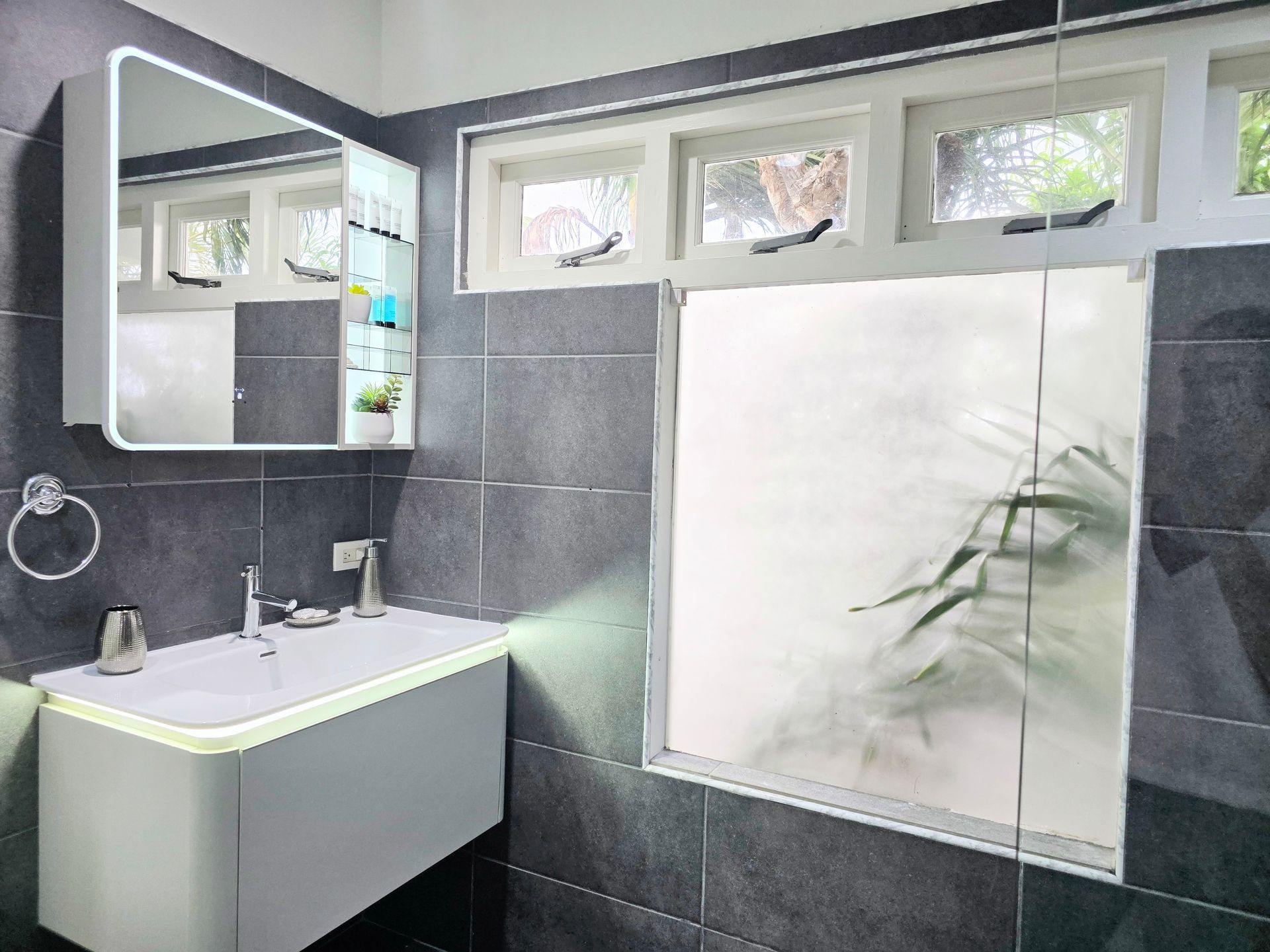 A bathroom with a sink and toilet and a walk in shower.