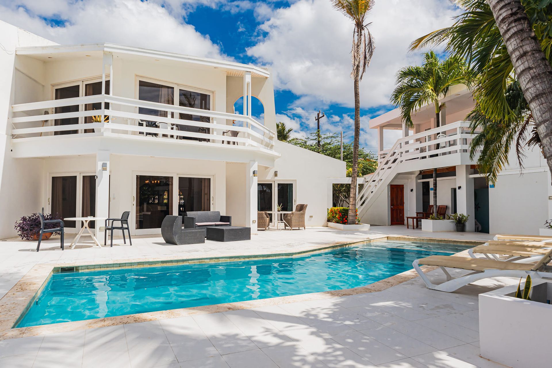 A large white house with a swimming pool in front of it.