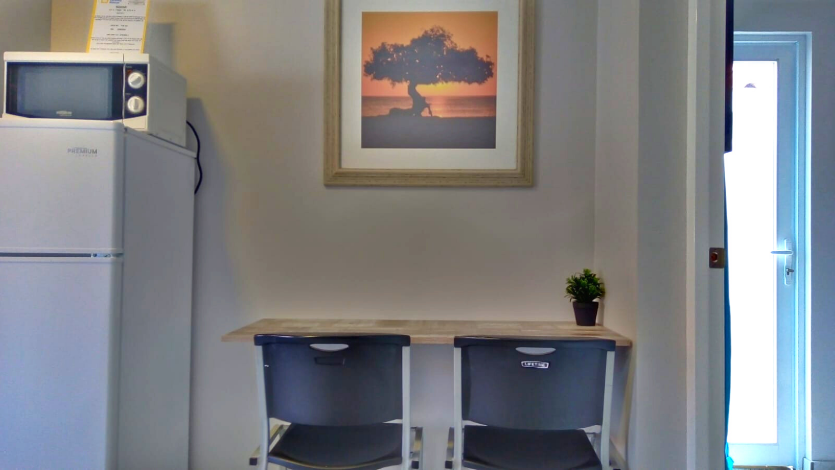 There is a picture of a tree on the wall above the table.