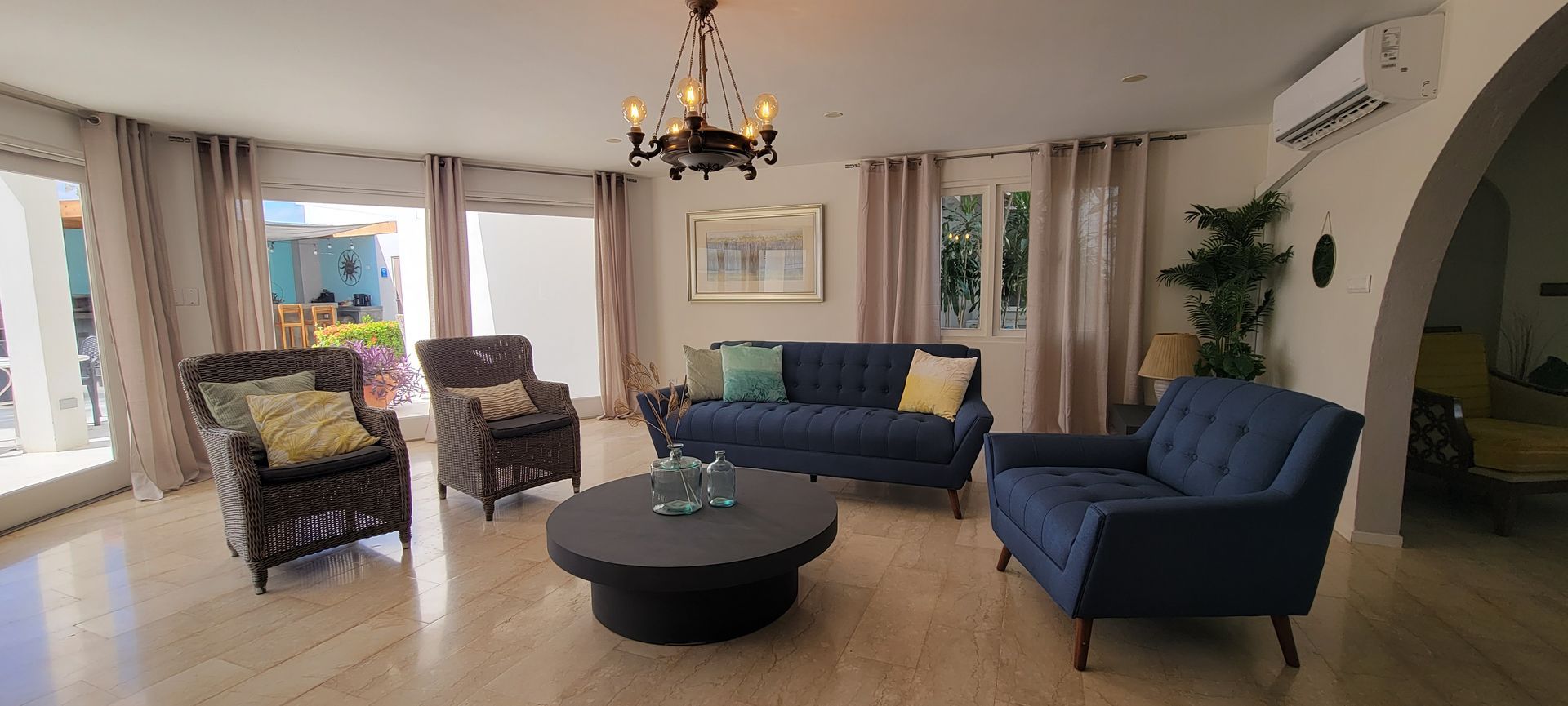 A living room with a couch , chairs , and a coffee table.