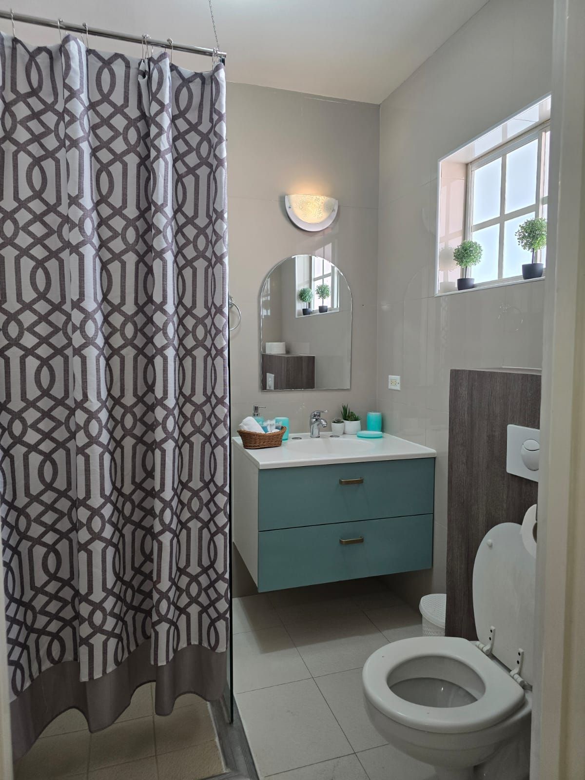 A bathroom with a toilet , sink , and shower.