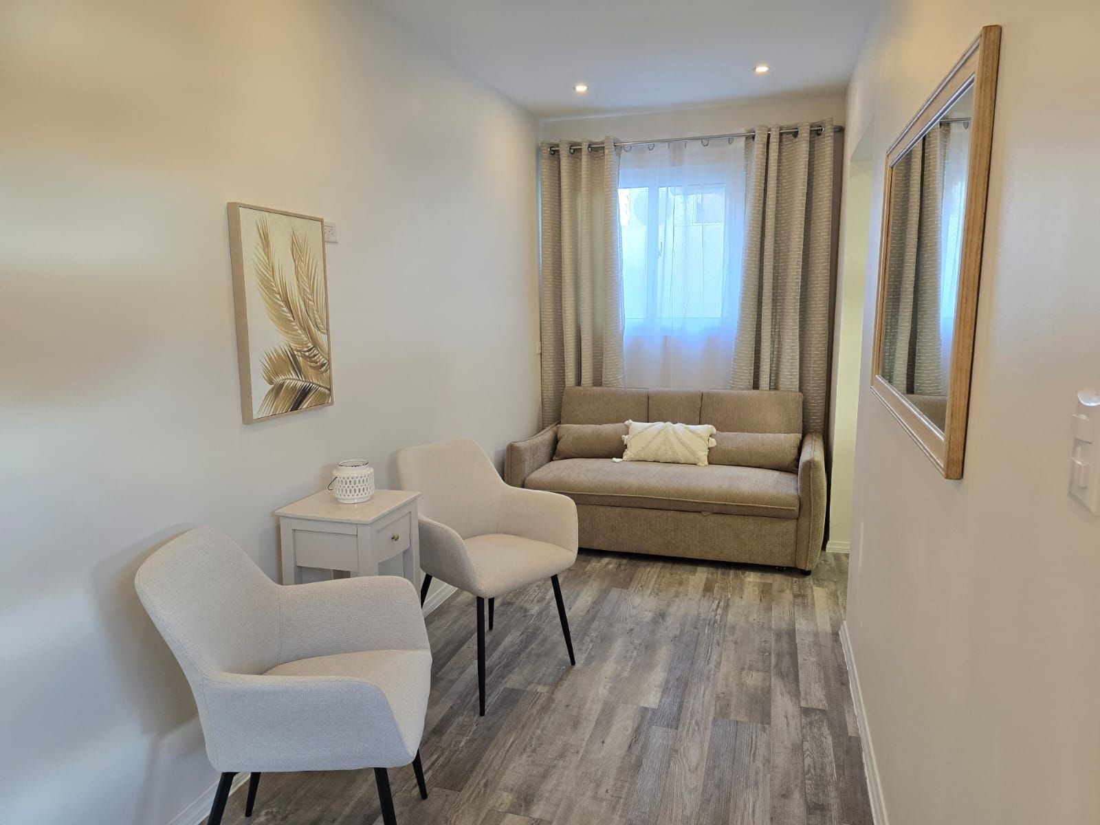 A living room with a couch , table and refrigerator