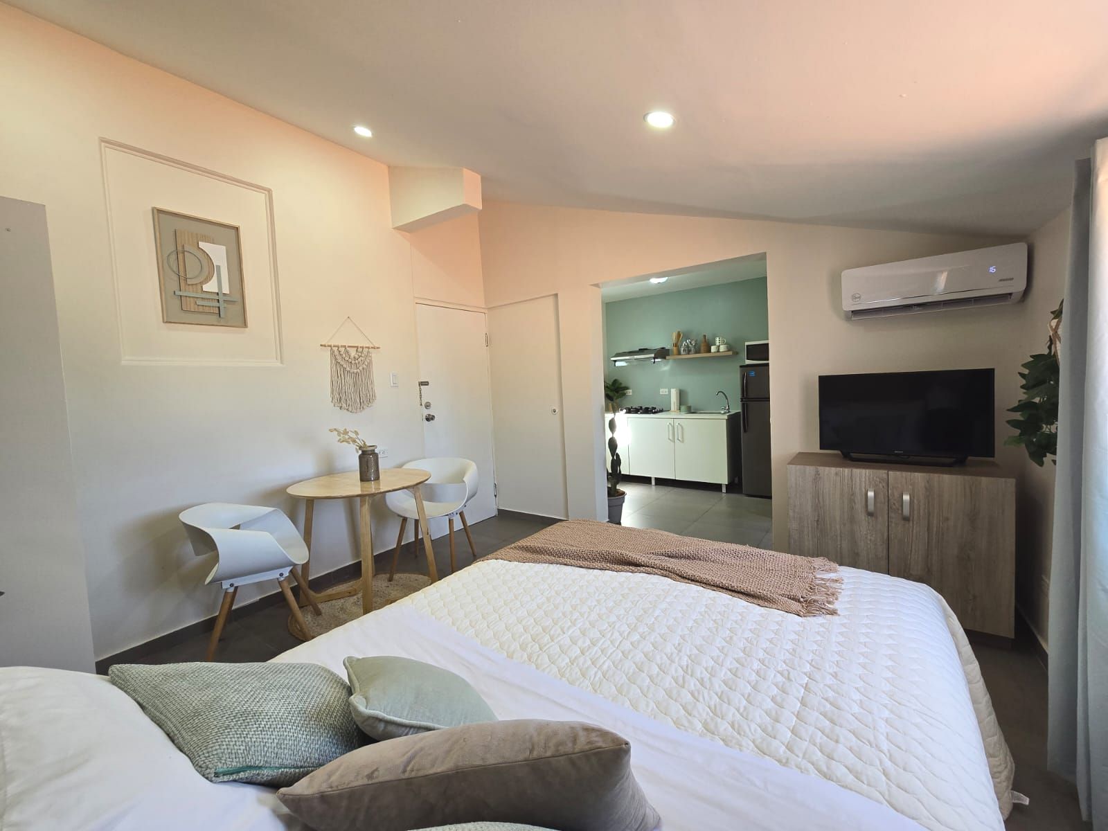 A bedroom with a bed , couch , desk and television.