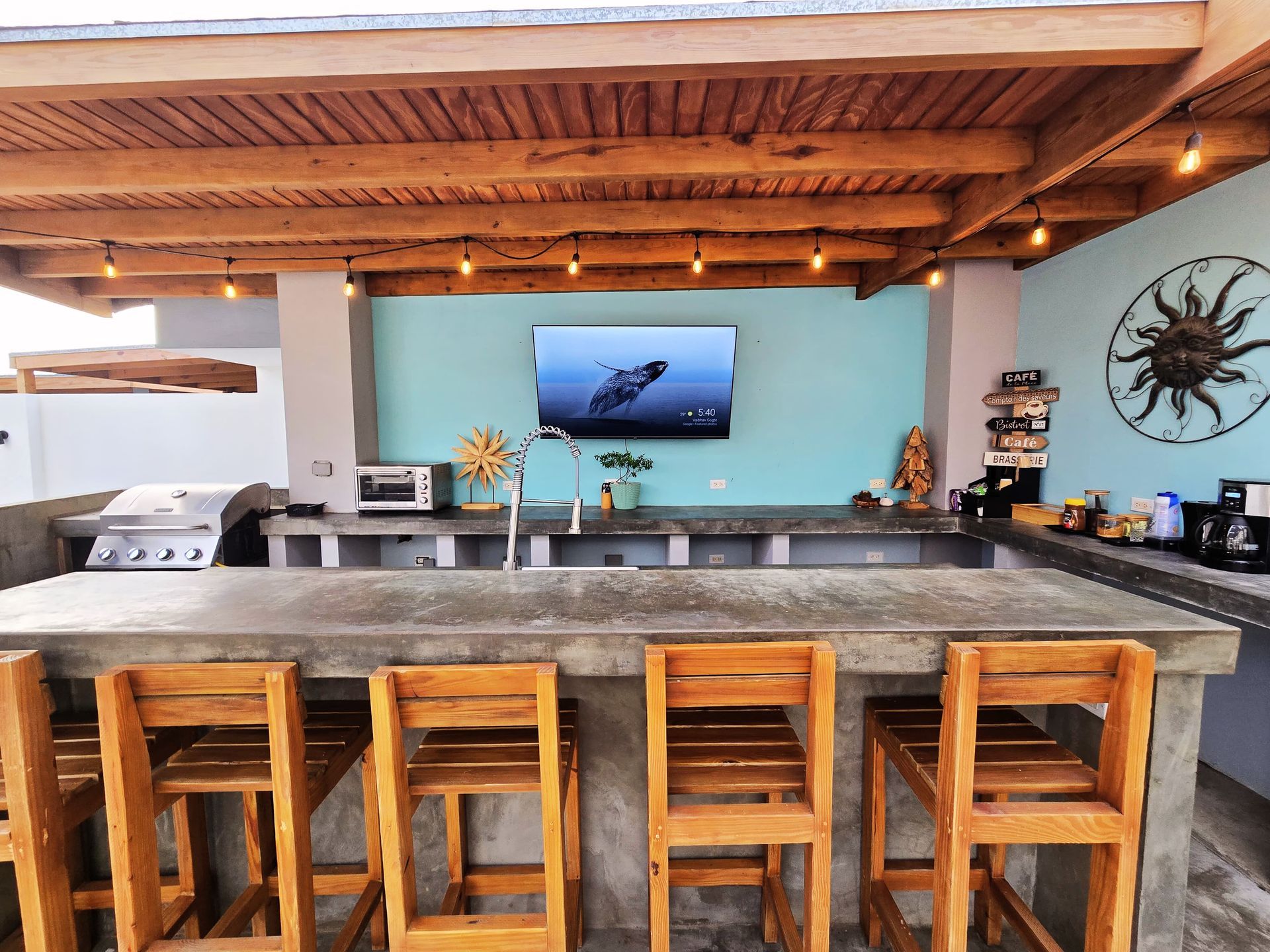 A kitchen with a table and chairs and a television on the wall.