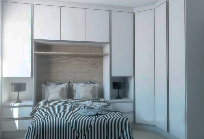 Há uma cama no meio do quarto com um cobertor listrado.
