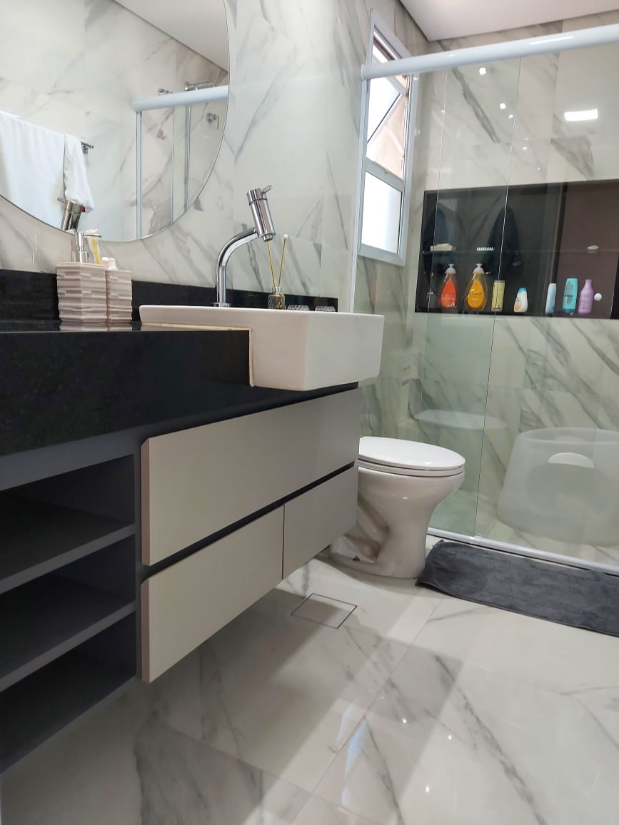 Um banheiro com pia, vaso sanitário e chuveiro.