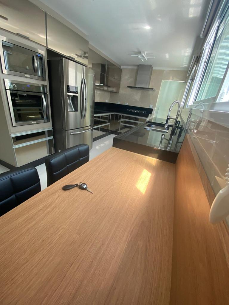 Uma cozinha com mesa e cadeiras e geladeira.