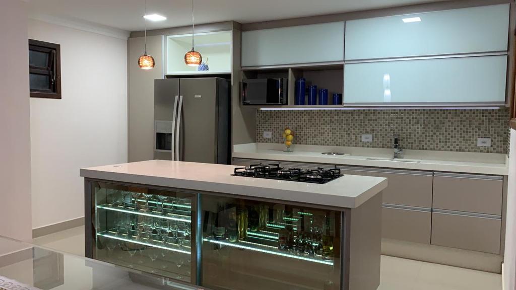 Uma cozinha com uma grande ilha e uma geladeira.