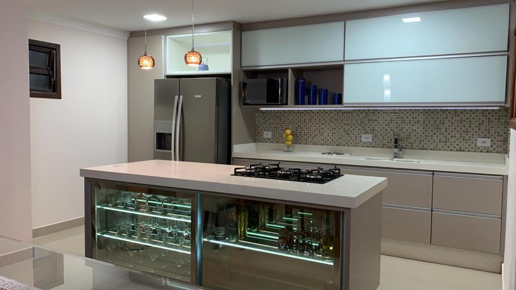 Uma cozinha com uma grande ilha no meio e uma geladeira.