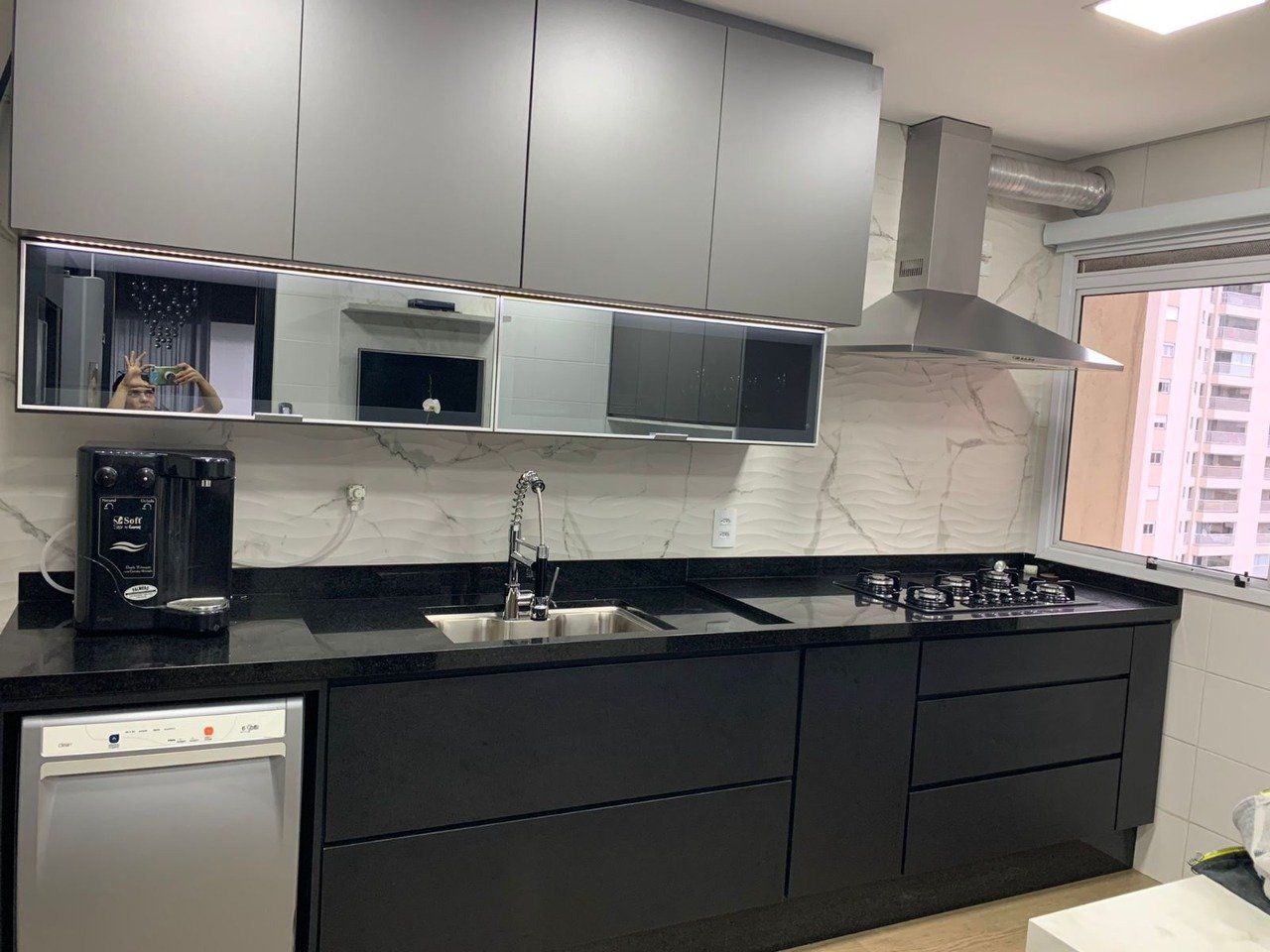 Uma cozinha com pia, fogão e lava-louças.