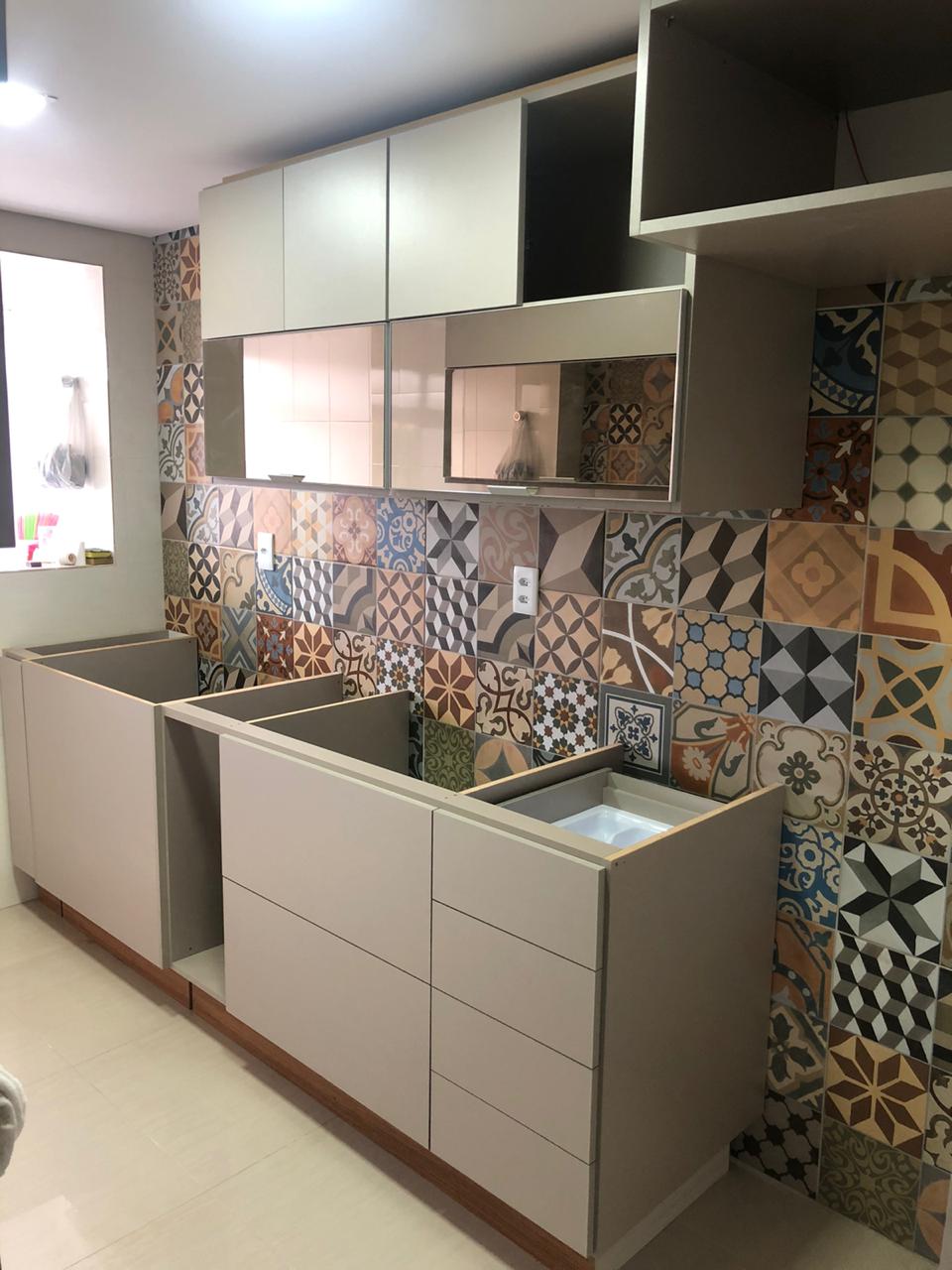 Uma cozinha com muitos armários e azulejos na parede.