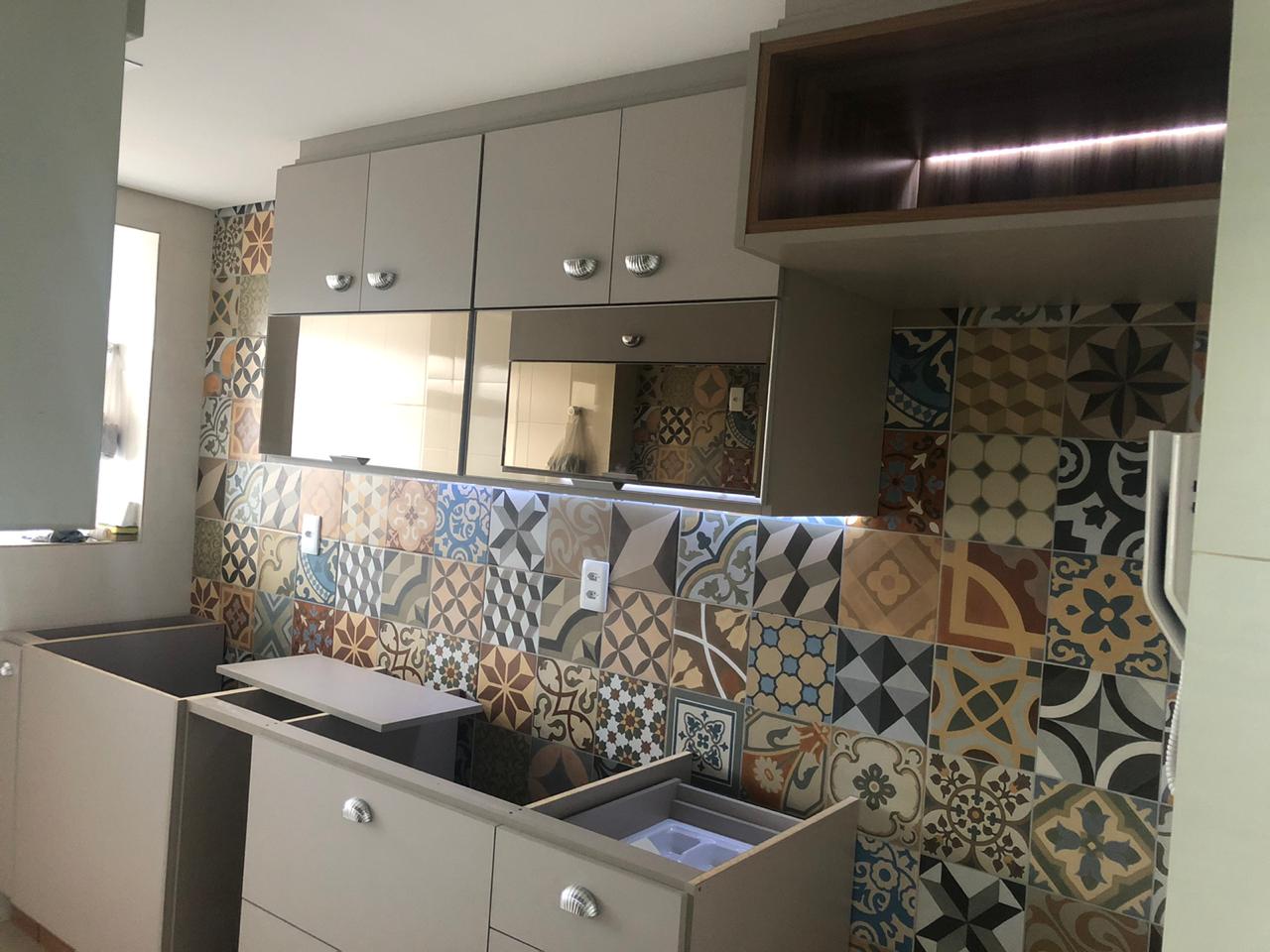 Uma cozinha com muitos armários e azulejos na parede.