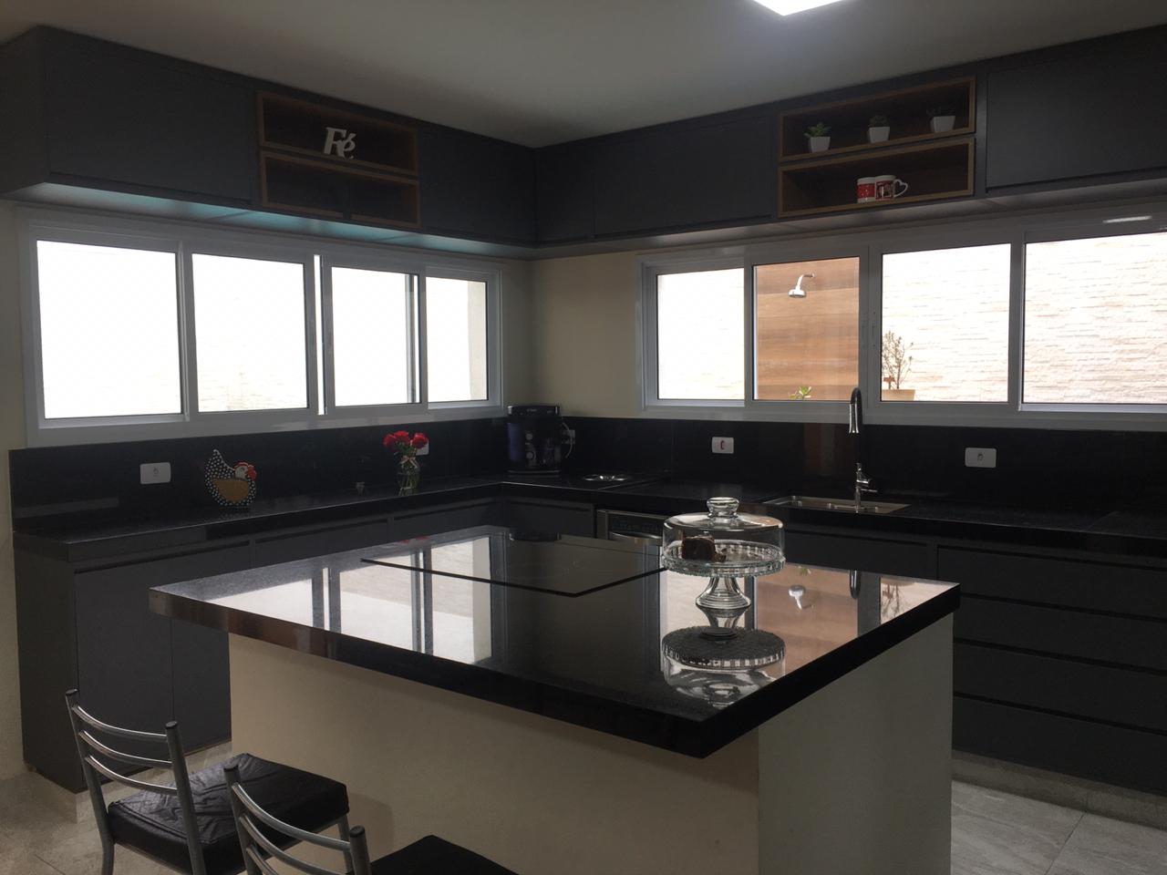 Uma cozinha com uma grande ilha e muitas janelas