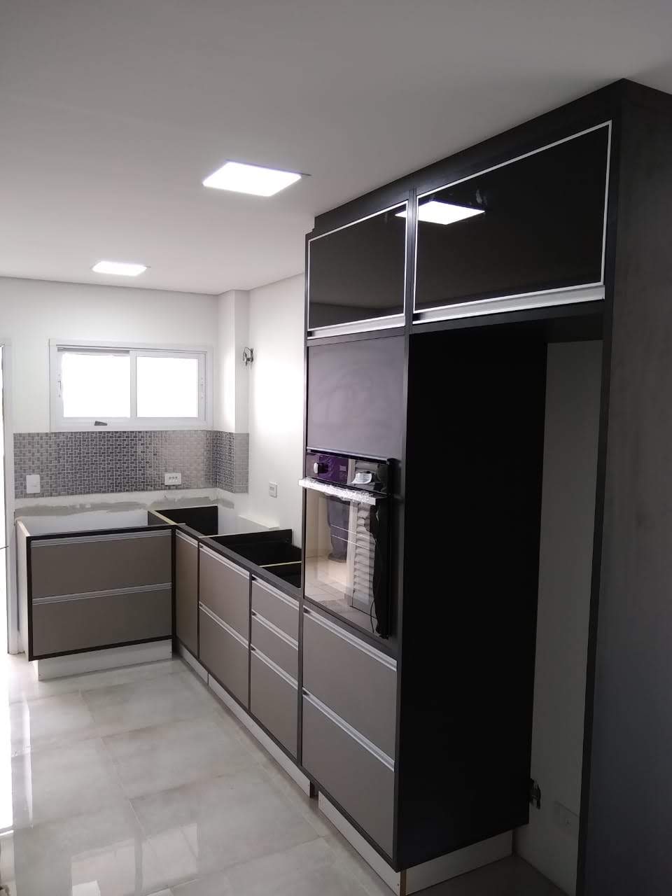 Uma cozinha com armários pretos e forno preto