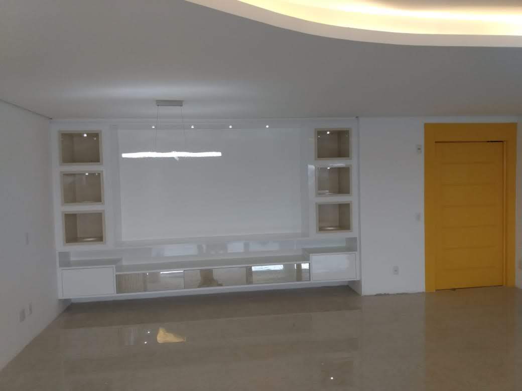 Uma sala vazia com uma porta amarela e um centro de entretenimento branco