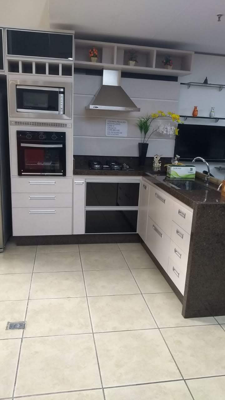 Uma cozinha com fogão, forno, micro-ondas e pia.