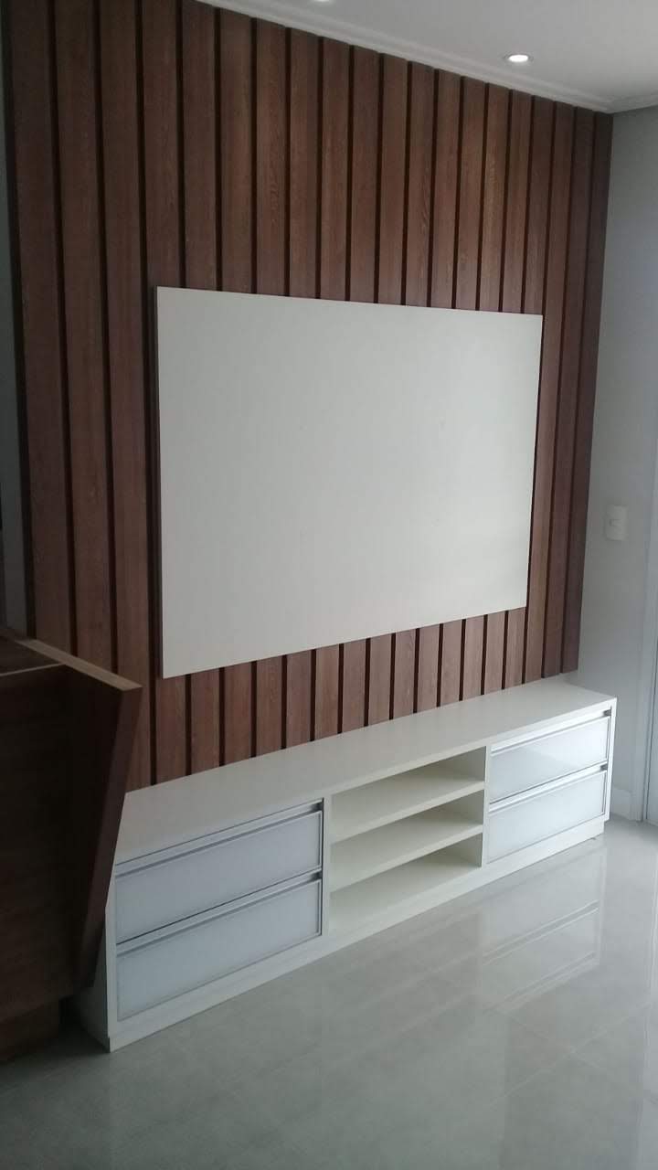 Uma sala de estar com TV de tela plana na parede.