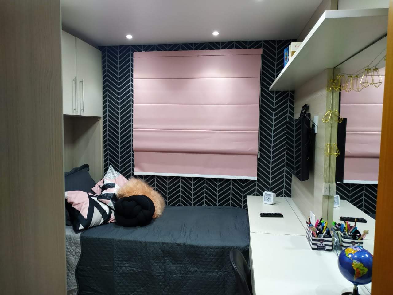 Um quarto com uma cama e uma mesa com um globo