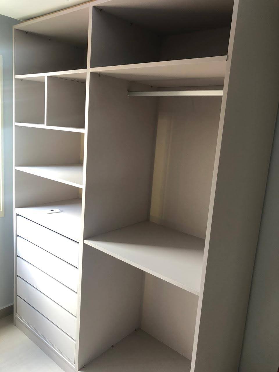 Um armário com muitas prateleiras e gavetas em uma sala