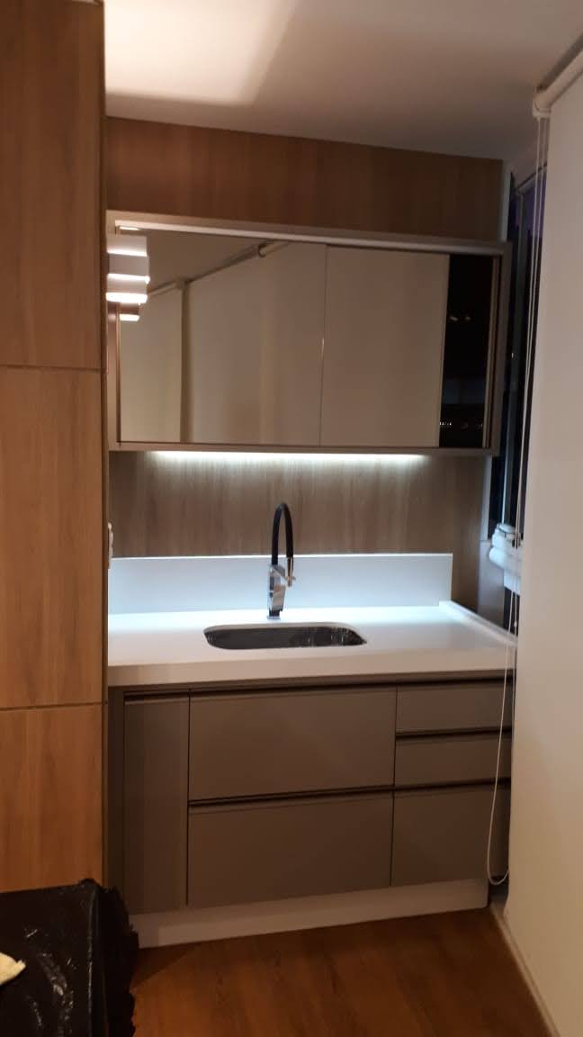 Uma cozinha com pia e espelho na parede