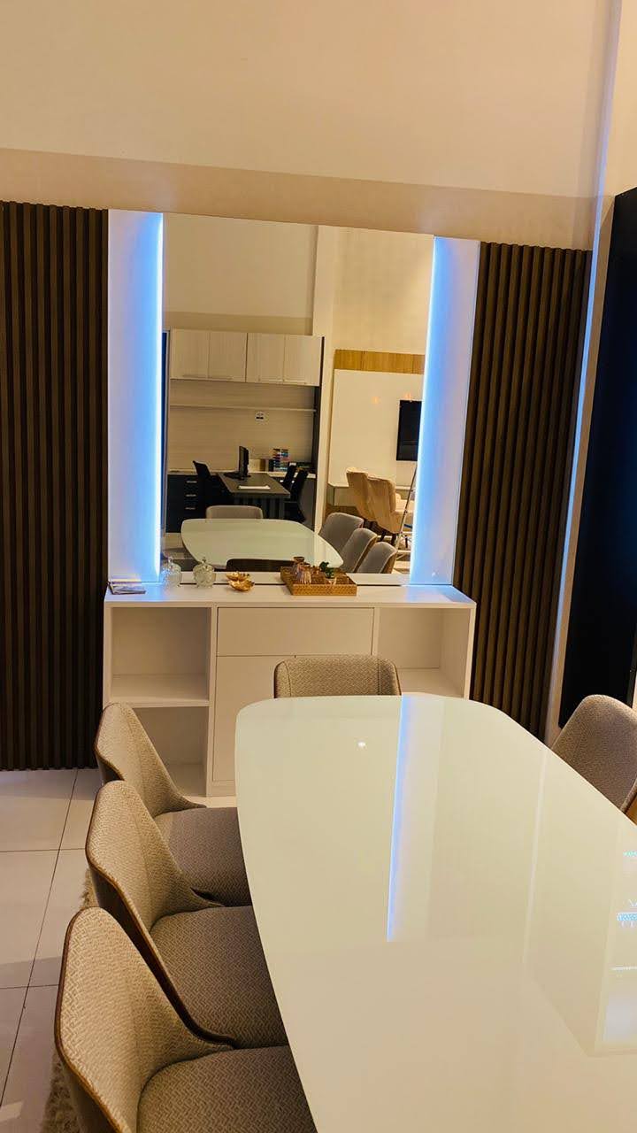 Uma sala de jantar com mesa e cadeiras e espelho