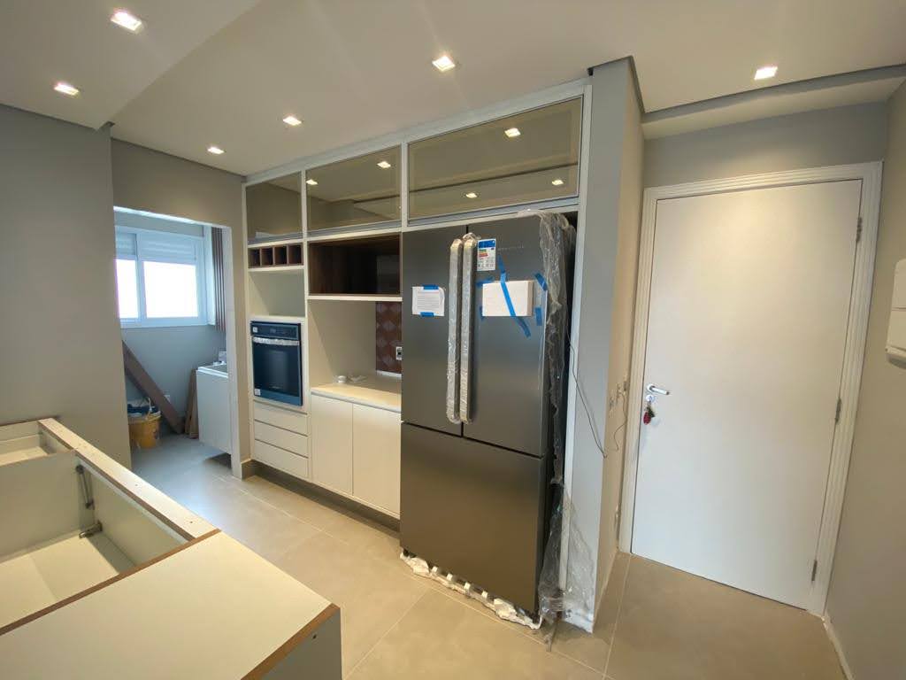 Uma cozinha com eletrodomésticos de aço inoxidável e geladeira.