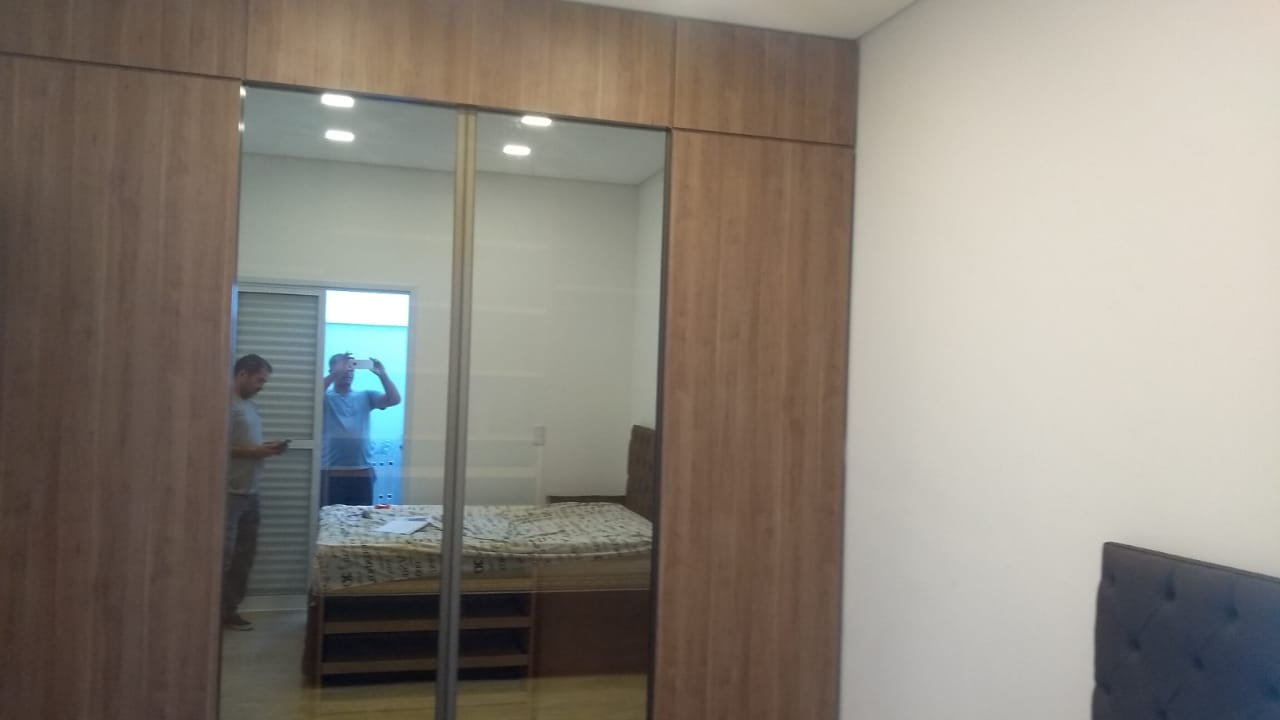 Um homem está tirando uma foto de si mesmo no espelho de um quarto.
