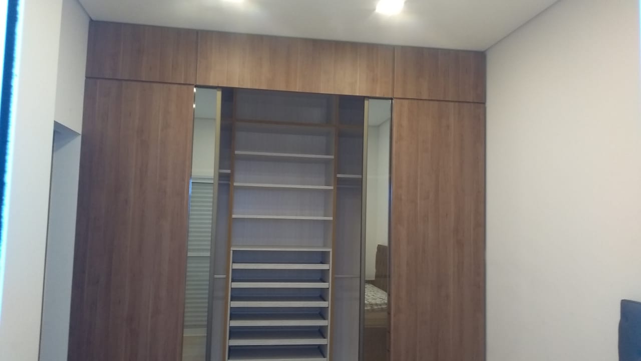 Um closet com portas de correr e prateleiras em um quarto.