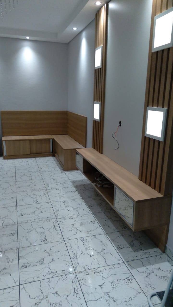 Uma sala de estar com sofá de madeira e piso de mármore