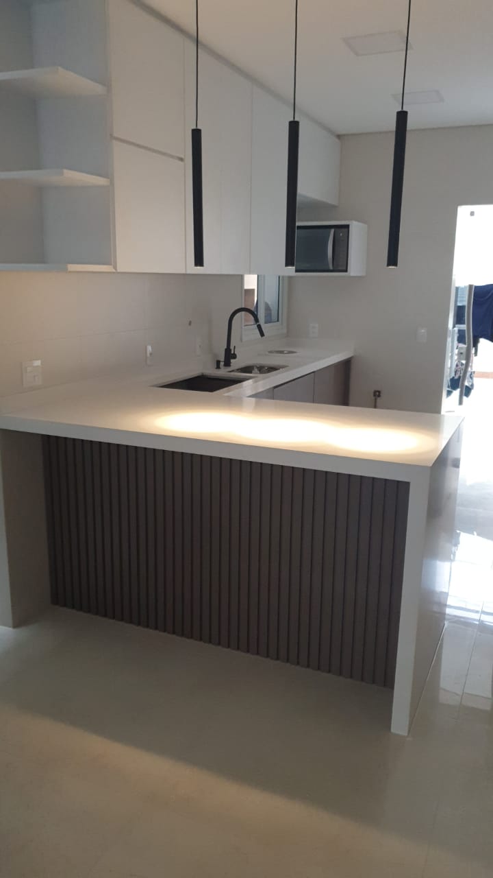 Uma cozinha com armários brancos e pia
