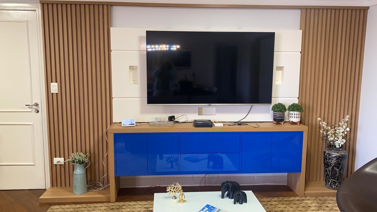 Uma sala com um armário azul e uma TV de tela plana na parede.