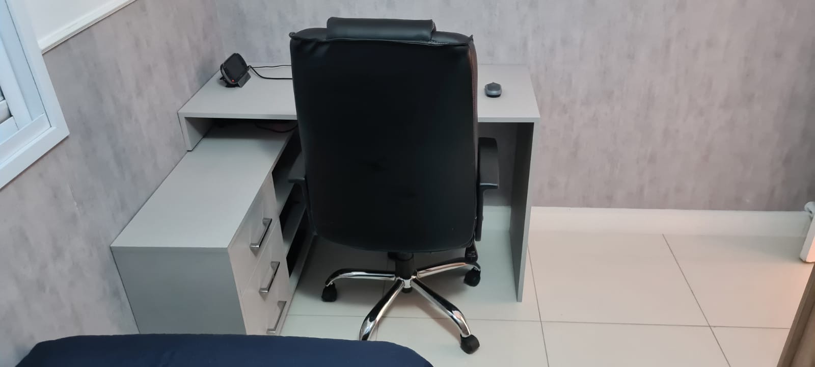 Uma cadeira está colocada em frente a uma mesa em uma sala.