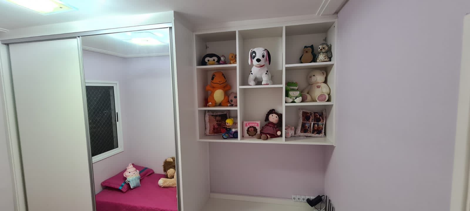Um quarto com cama e prateleiras cheias de bichinhos de pelúcia.