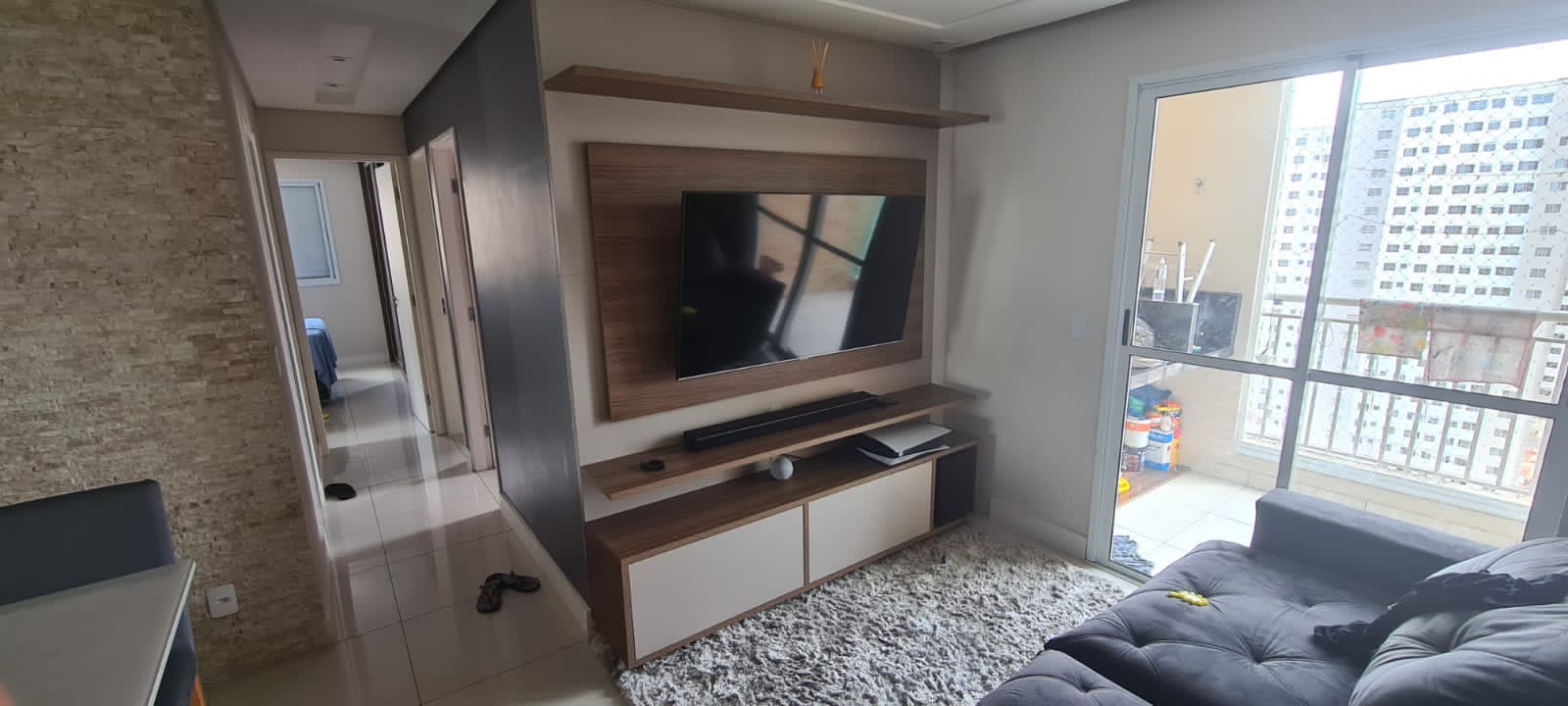 Uma sala de estar com sofá e TV de tela plana.