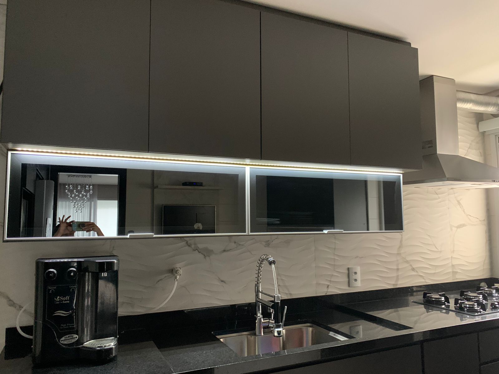 Uma cozinha com armários pretos e uma pia