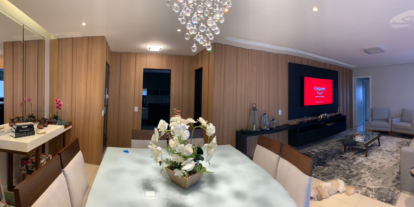 Uma mesa de jantar com um vaso de flores em uma sala de estar.