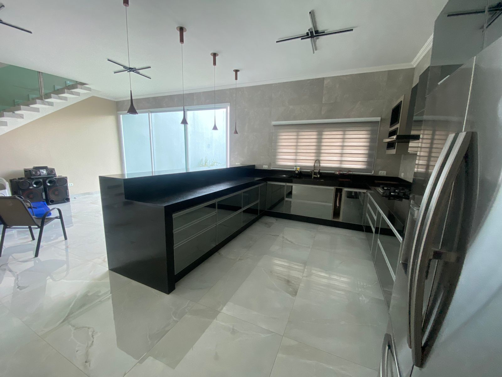 Uma cozinha com eletrodomésticos em inox e uma grande ilha no meio da sala.