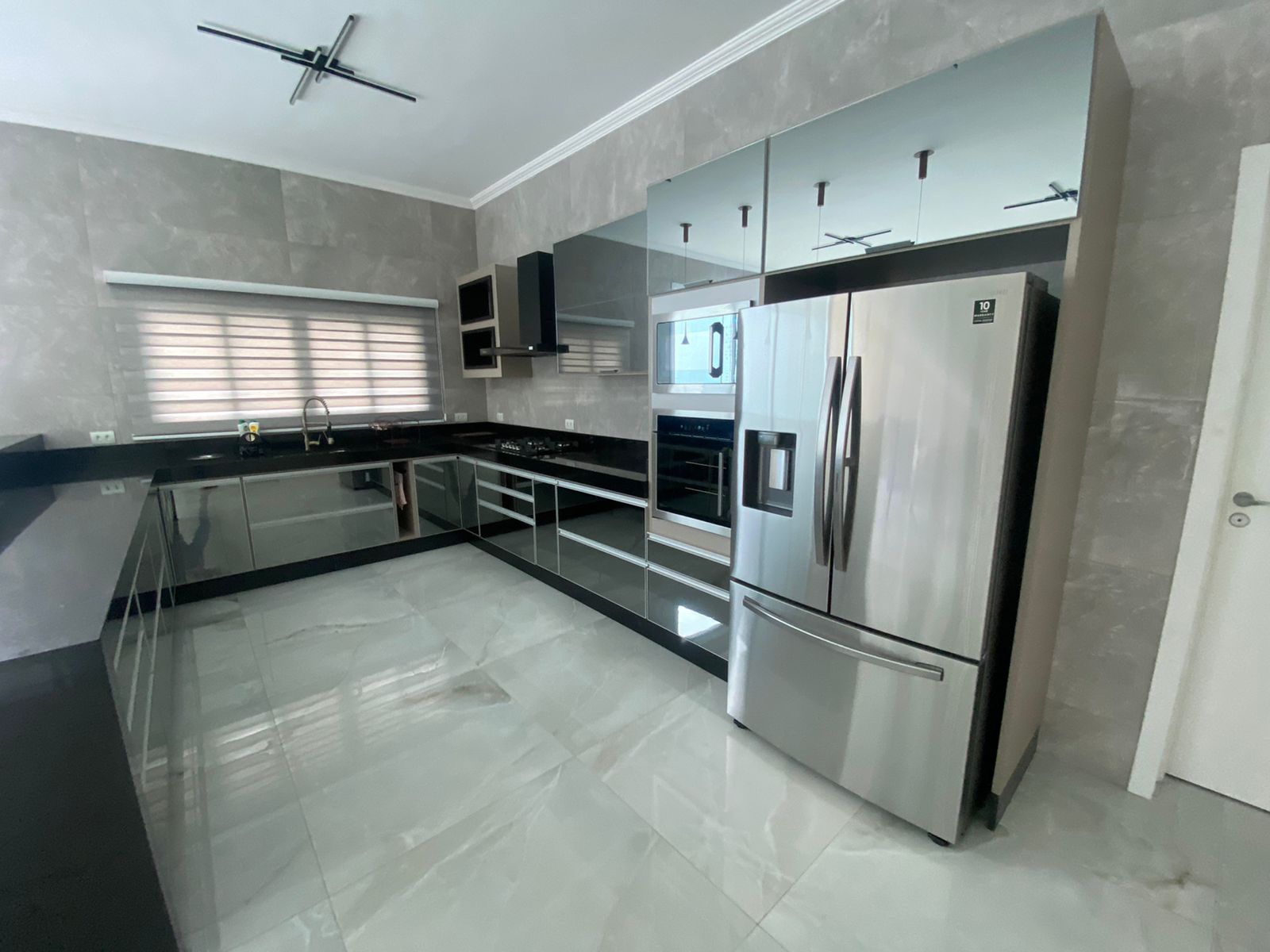 Uma cozinha com eletrodomésticos em inox e armários espelhados.