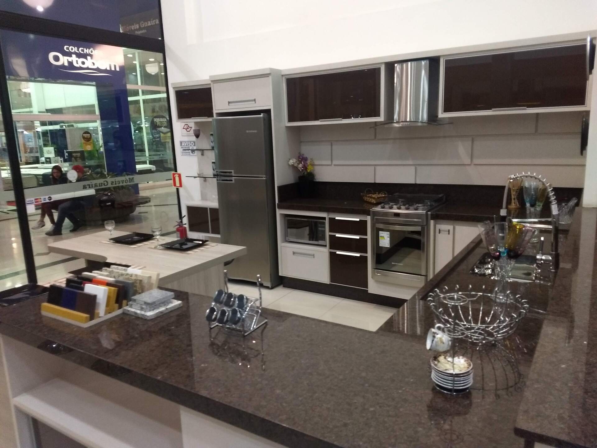 Uma cozinha com eletrodomésticos de aço inoxidável e bancadas de granito