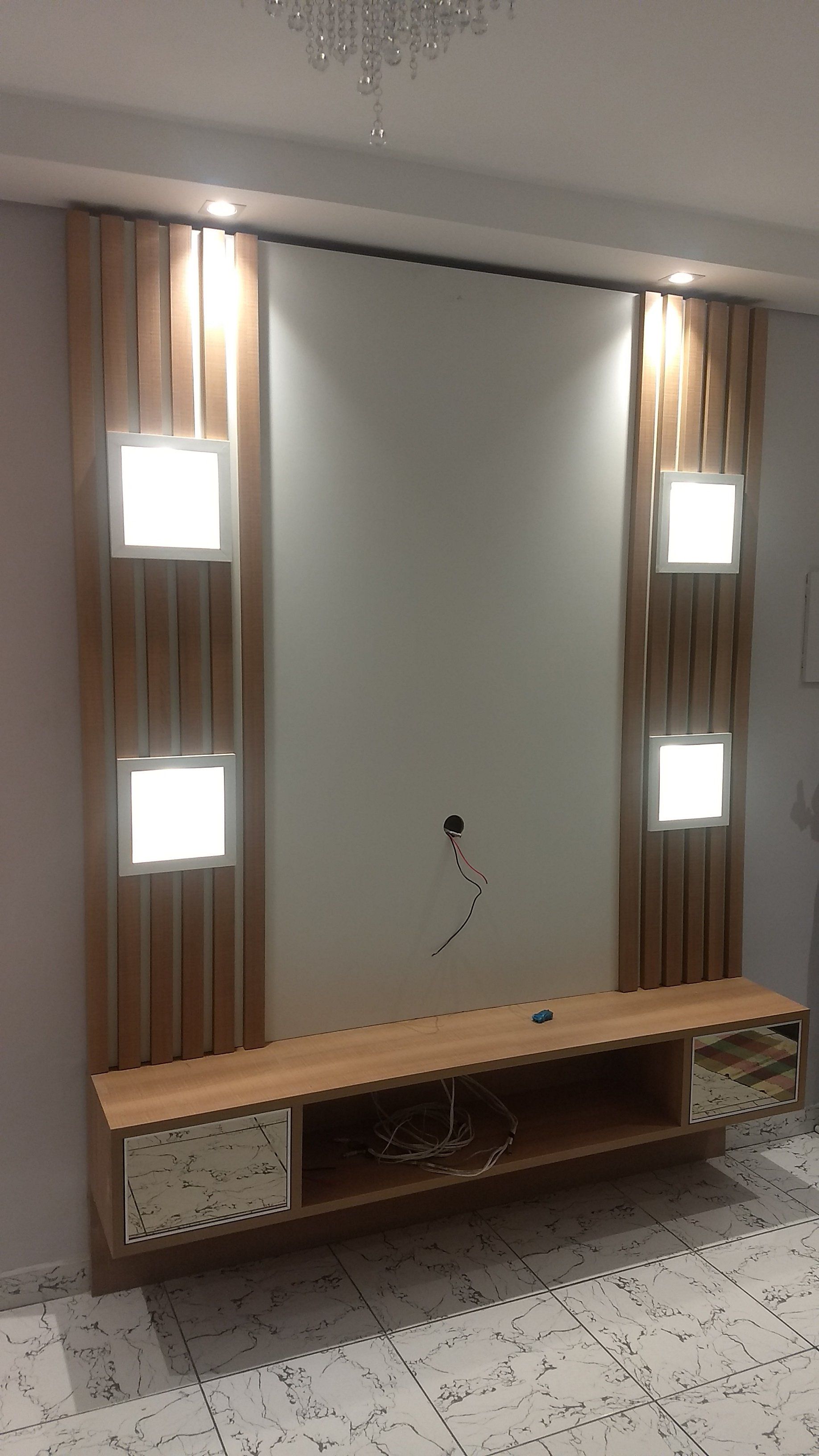 Uma sala de estar com um centro de entretenimento de madeira e uma TV na parede.