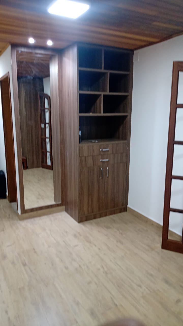 Uma sala com um grande espelho e armários de madeira