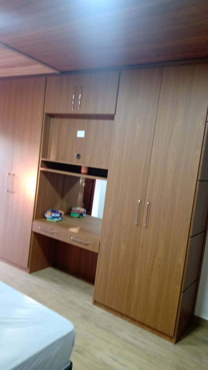 Um quarto com muitos armários de madeira e uma cama